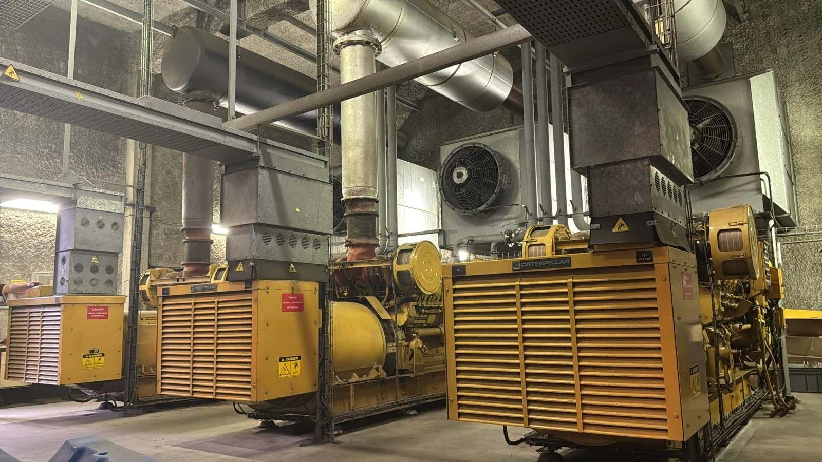 Local technique avec plusieurs groupes électrogènes Caterpillar, leurs radiateurs et leurs gaines d’échappement