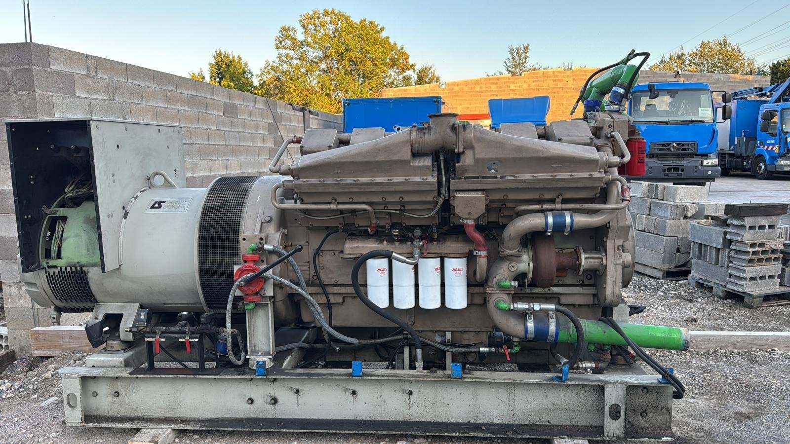 Groupe électrogène ouvert sur châssis, moteur Cummins peint en vert et alternateur Leroy-Somer, posé en extérieur