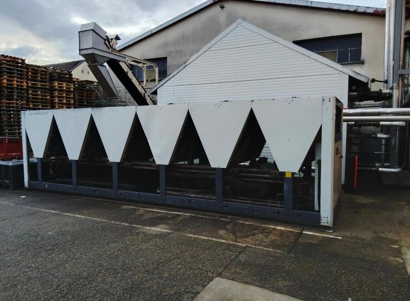 Groupe froid à condensation par air CIAT PowerCIAT installé en extérieur, devant un bâtiment industriel