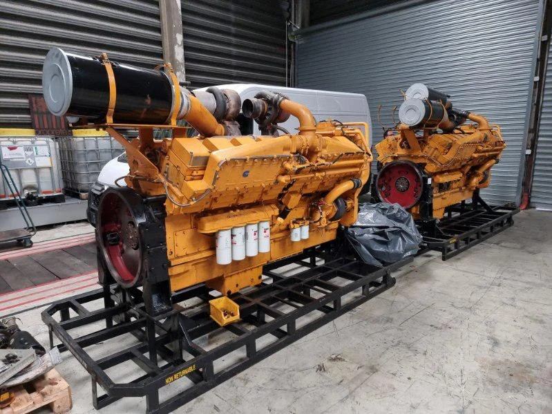 Deux moteurs diesel Caterpillar jaunes sur châssis, sans alternateur, dans un entrepôt